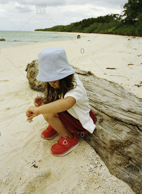 Girl playing in sand on a beach