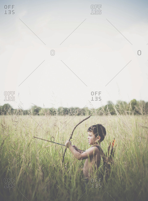 Side-view of little boy practicing archery