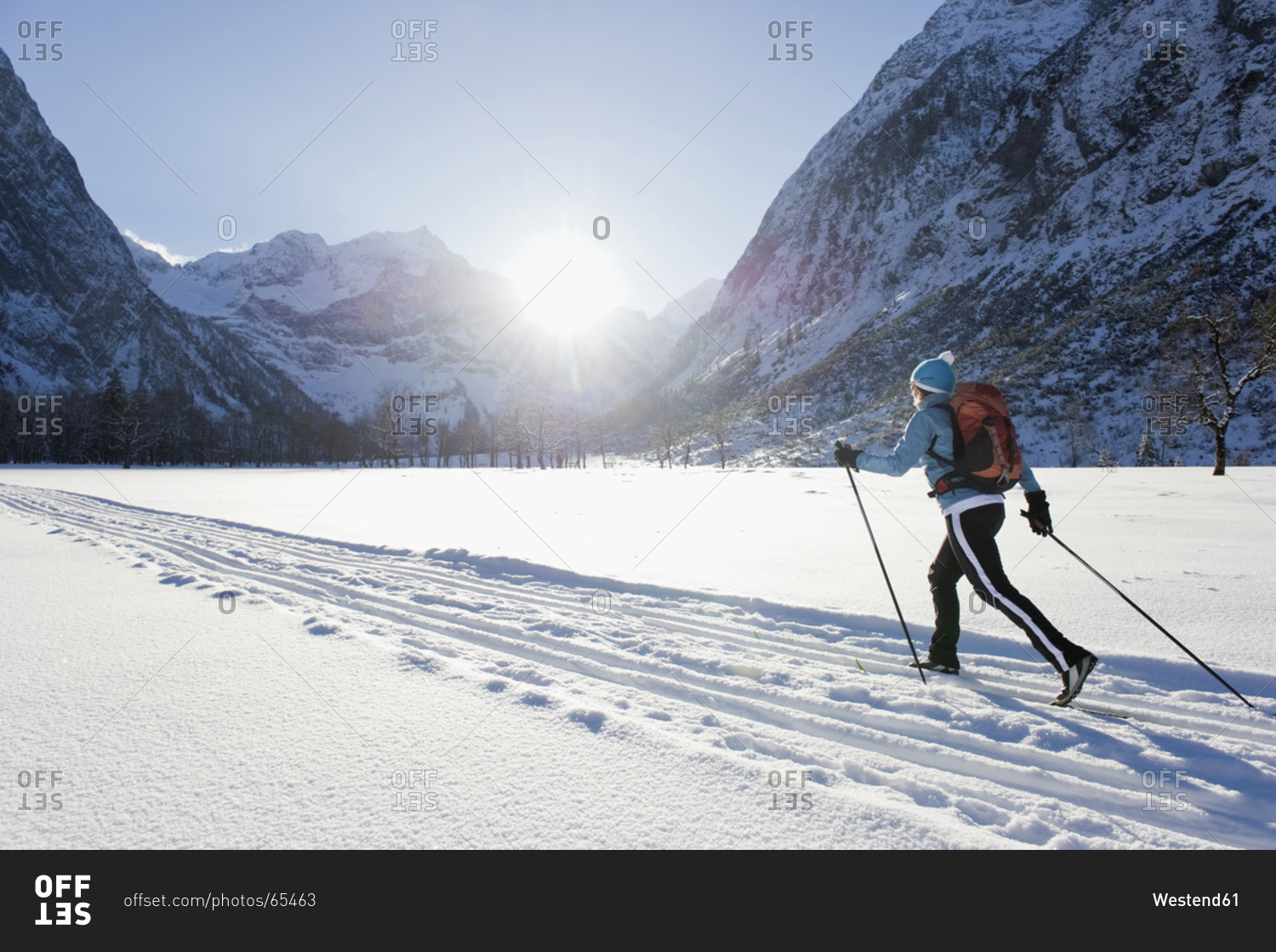 Senior woman doing cross-country skiing with karwendal mountains in background