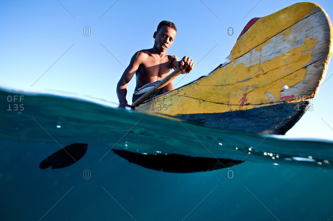 Young Vezo fisherman rowing in pirogue boat