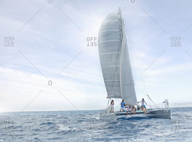 Friends riding sail boat in water