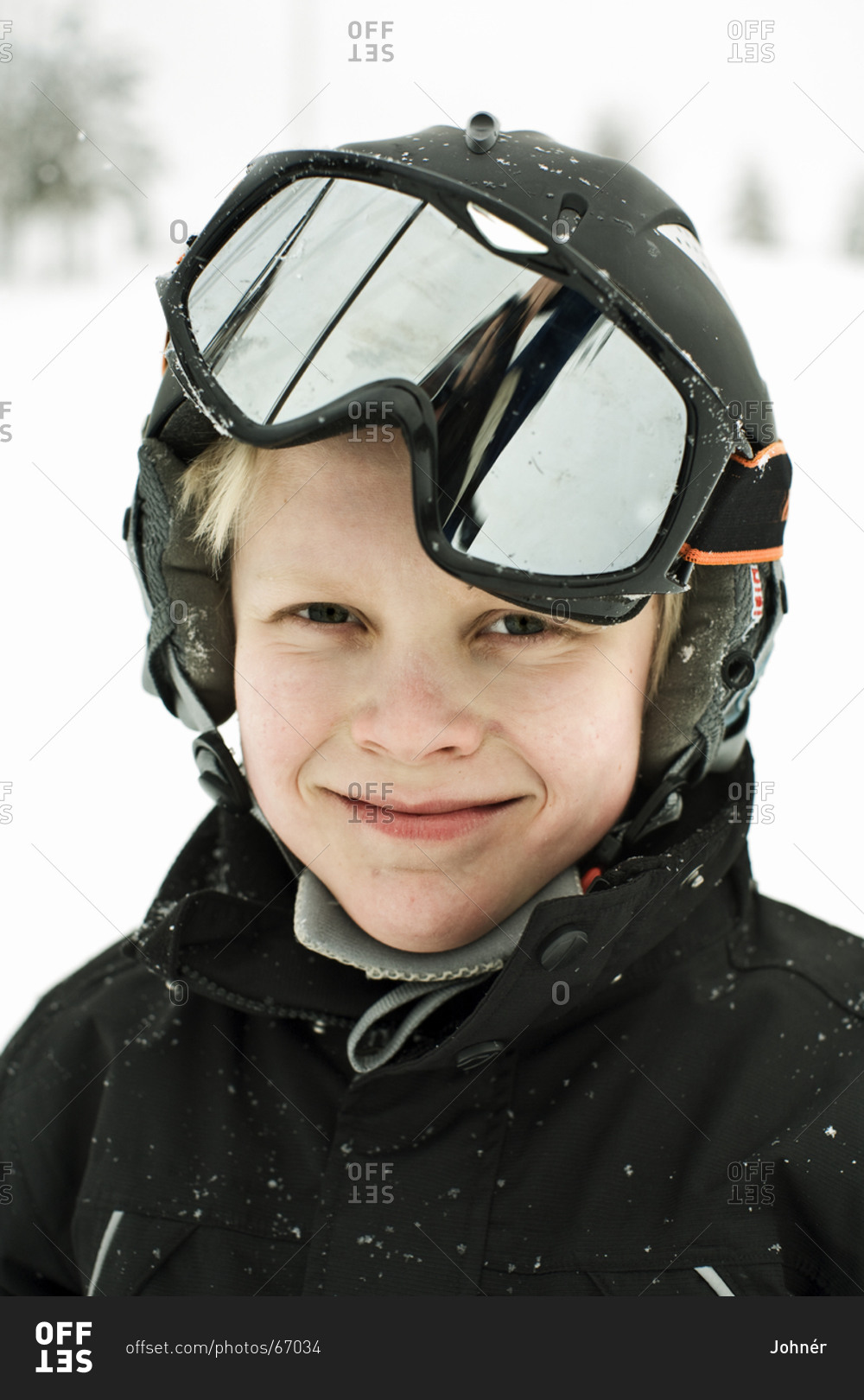 Portrait of boy wearing ski goggles and safety helmet stock photo OFFSET