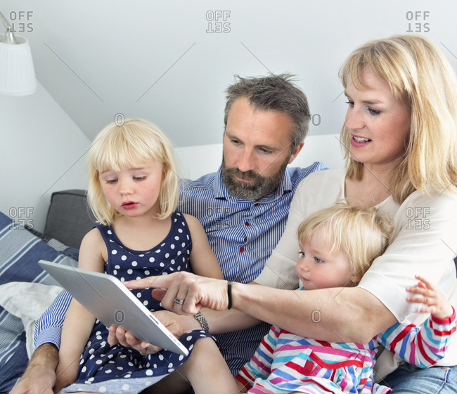 Parents with daughters using digital tablet
