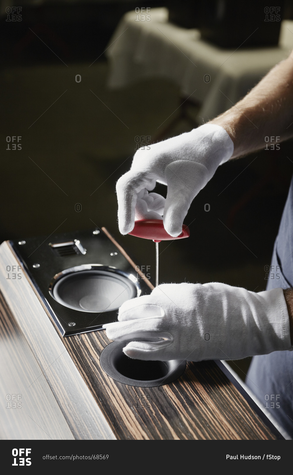 A repairman working an audio speaker