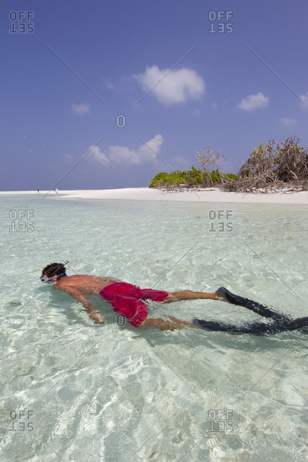 Snorkeler enjoying a remote atoll in the Maldives chain, Indian Ocean