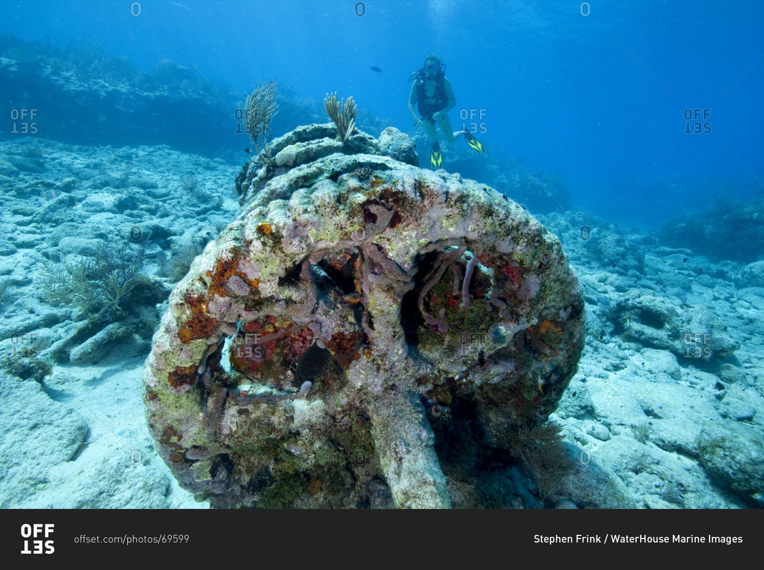 Teenage scuba diver approaches a set of winch gears located at a dive site known as the 