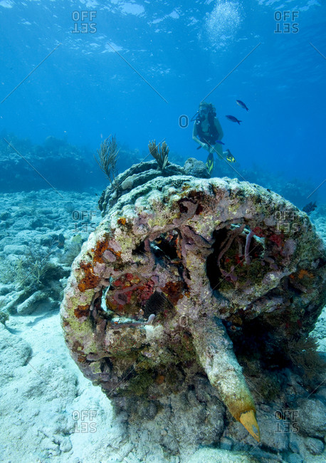 Teenage scuba diver approaches a set of winch gears located at a dive site known as the "Winch Hole" on Molasses Reef