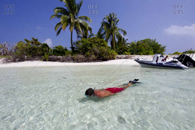 Snorkeler enjoying a remote atoll in the Maldives chain, Indian Ocean