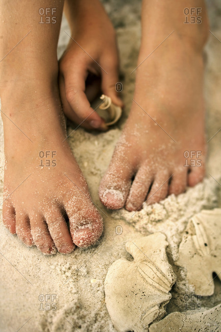Girl picking up shell from the sand