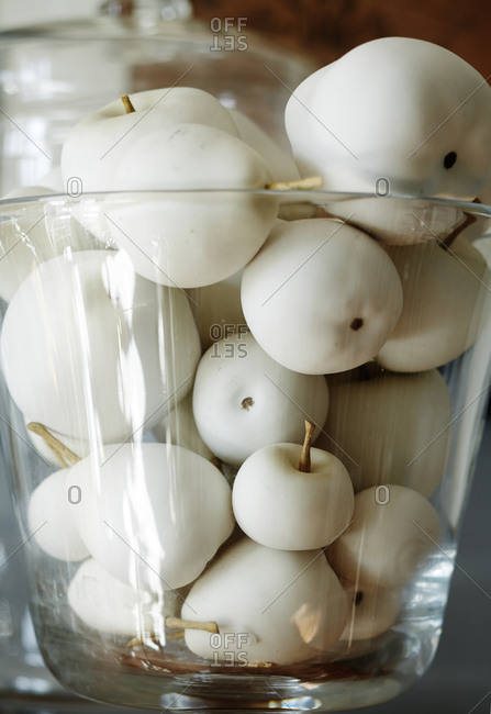 Close-up of plastic pears and apples in glass bowl