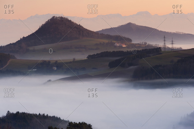 Germany, View of foggy landscape with pylon and mountain