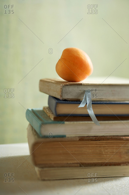 Close-up of an apricot on a stack of books
