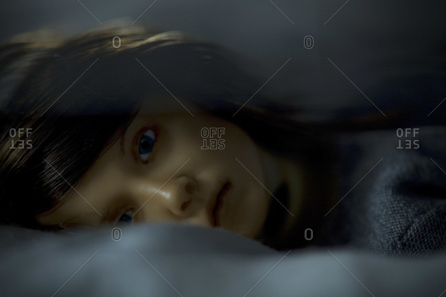 Close-up of a puppet lying in bed