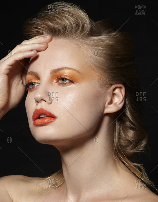 Head shot of model in orange eye shadow and lipstick