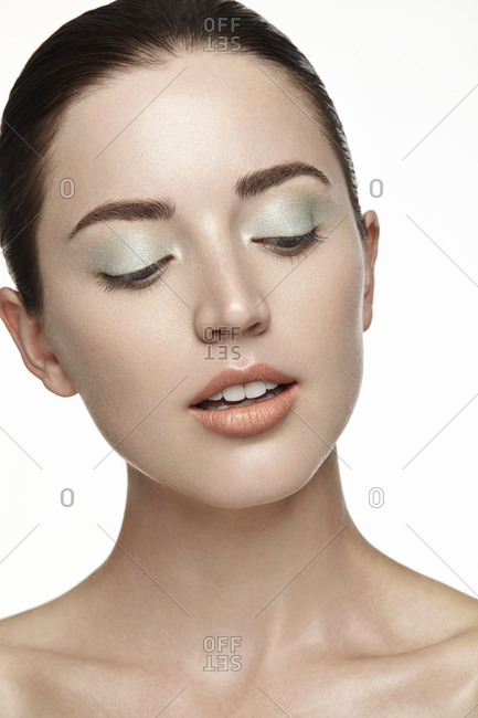 Brunette model wearing coral lipstick and light green eye shadow