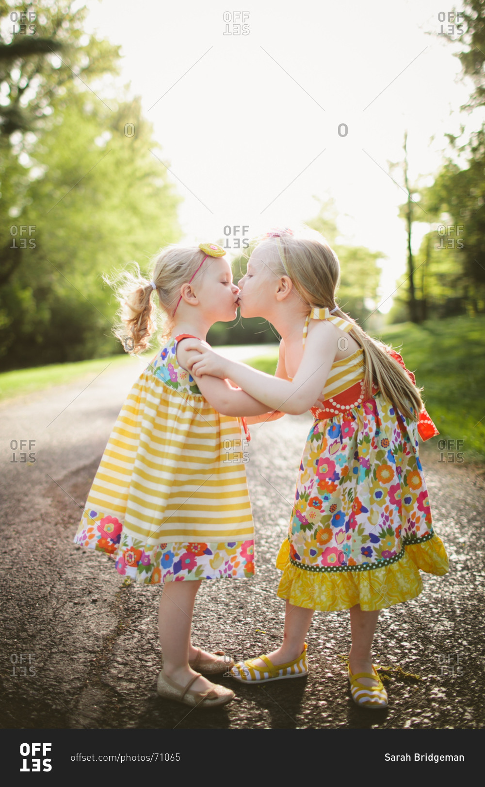 two-cute-sister-kissing-and-hugging-in-forest-stock-photo-offset