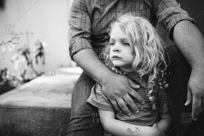 A young boy sitting a some steps with an adult