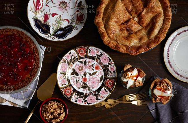 Top view of cranberry-glazed pumpkin pie, an old-fashioned apple pie and pear and fig pie in a jar