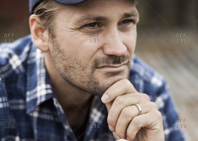 Close-up of thoughtful farmer with hand on chin looking away
