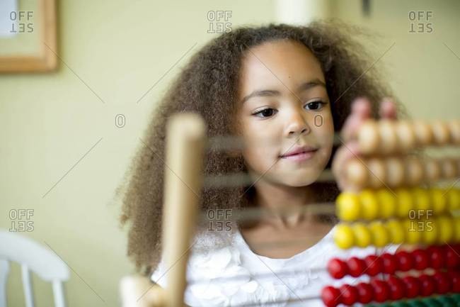 Mixed race girl using abacus