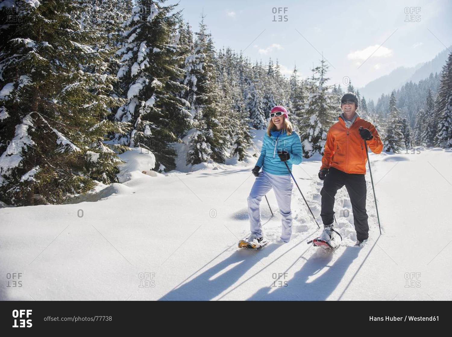 Couple snowshoeing in winter landscape