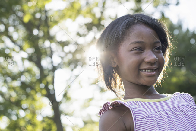 A Young Girl With Short Hair In A Striped Sundress Smiling Stock