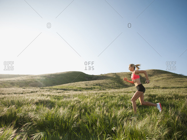 Caucasian woman running in remote field