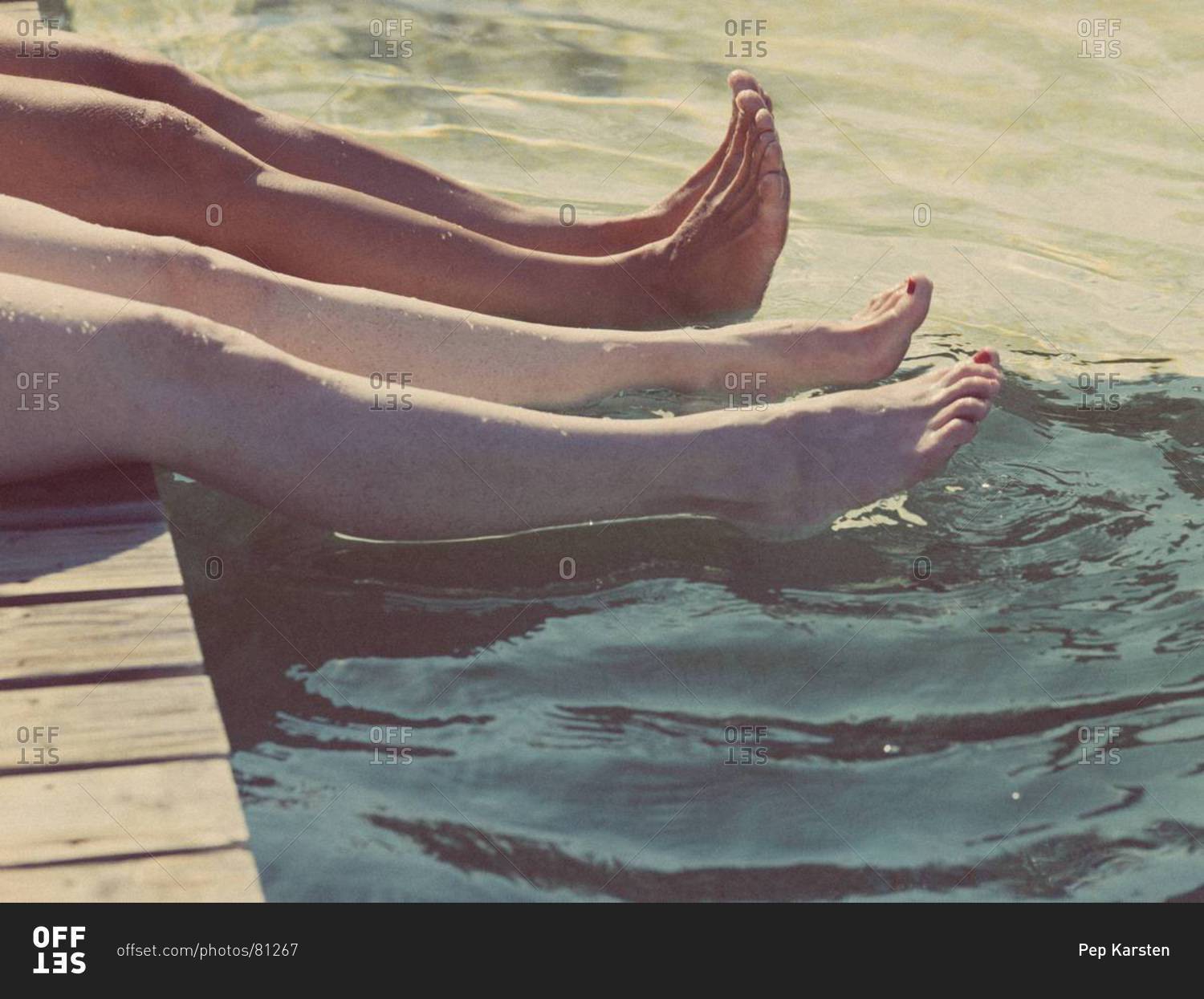 Two women dipping feet in water