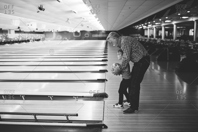 Young girl bowling with her Grandfather