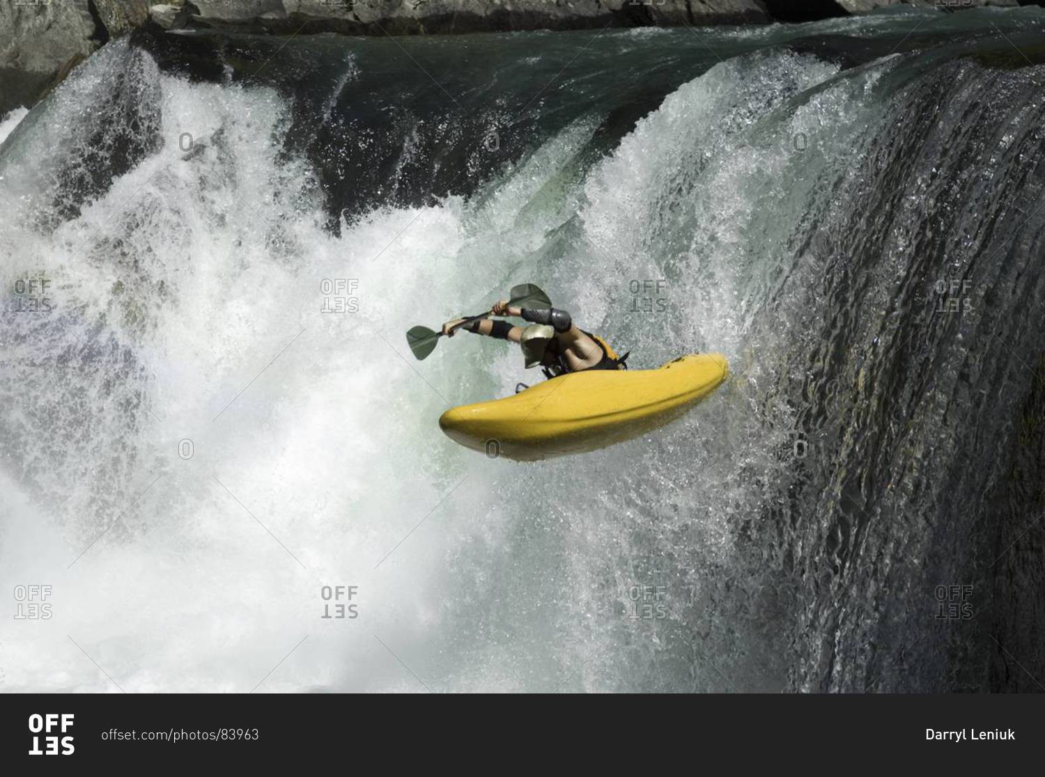 Male kayaker going over a waterfall