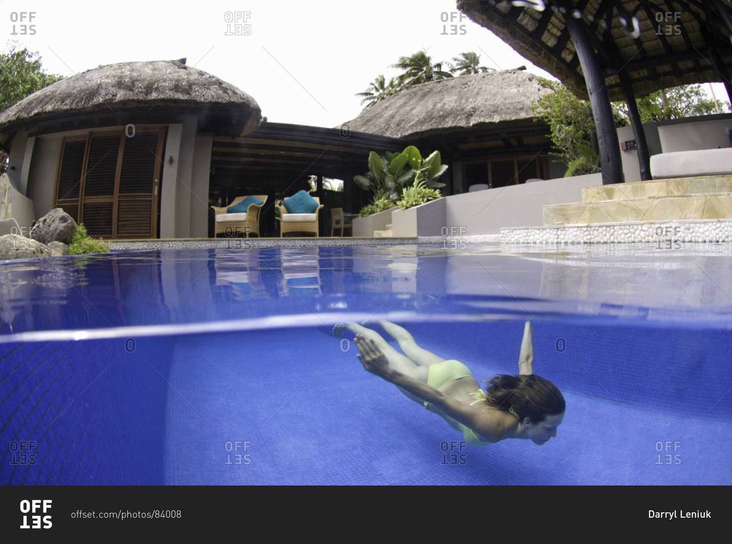 Woman swimming in pool in tropical resort, underwater view, Fiji