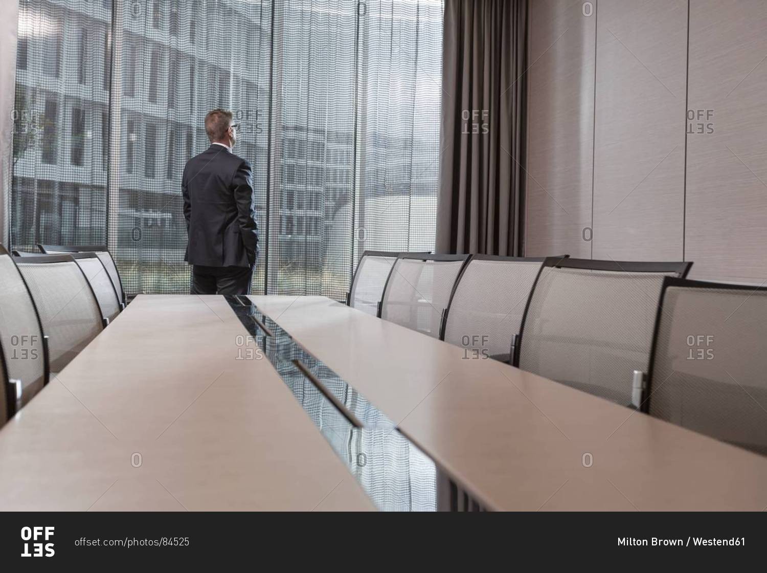 Poland, Warzawa, businessman looking  out of window in conference room at hotel