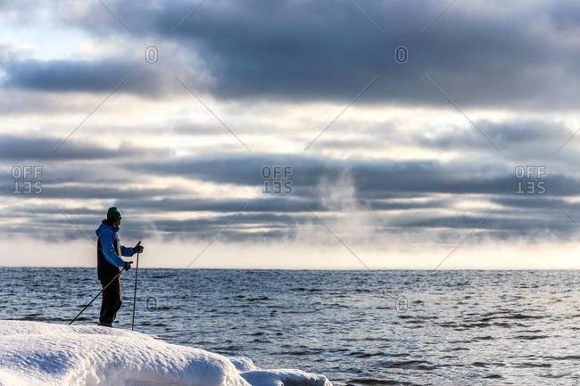 Skier looking at sea, Ingaro, Sweden