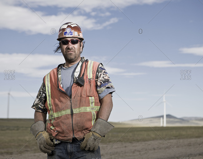 Worker posing in front of wind turbines