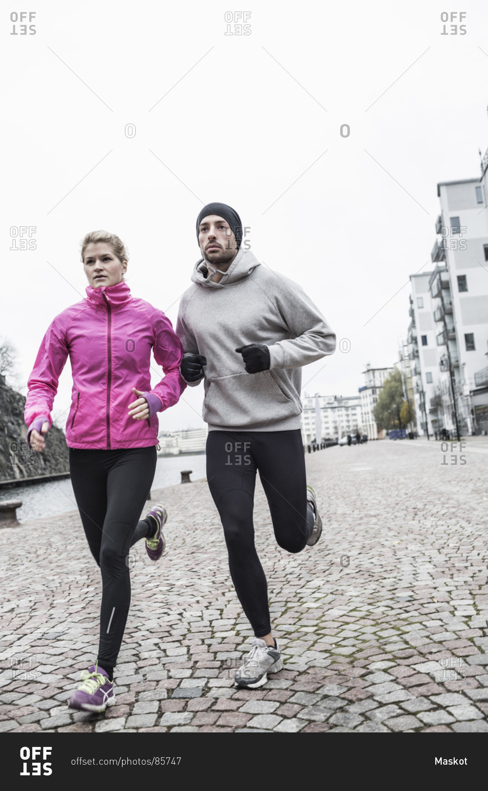 Sporty couple running on street