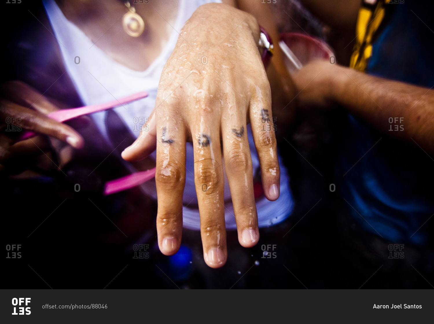 Close up of a woman's hand with love tattooed to her fingers celebrating Songkran, the Thai New Year, Bangkok, Thailand.