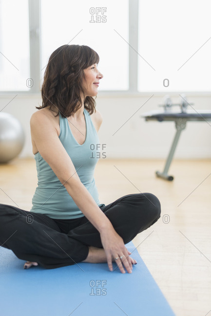 Slim woman in sportswear looking at camera while doing plank on