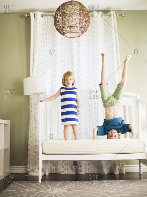 Brother and sister standing on daybed