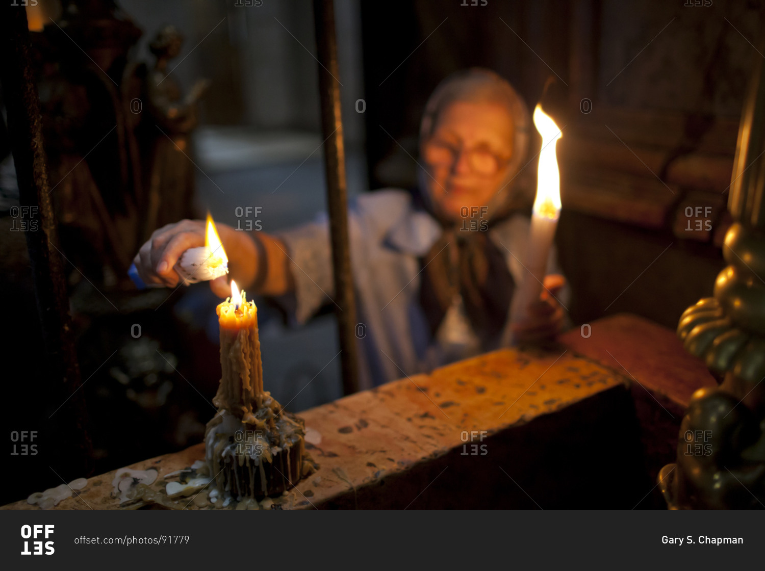Orthodox Christian woman lights candles at the Church of the Holy Sepulchre