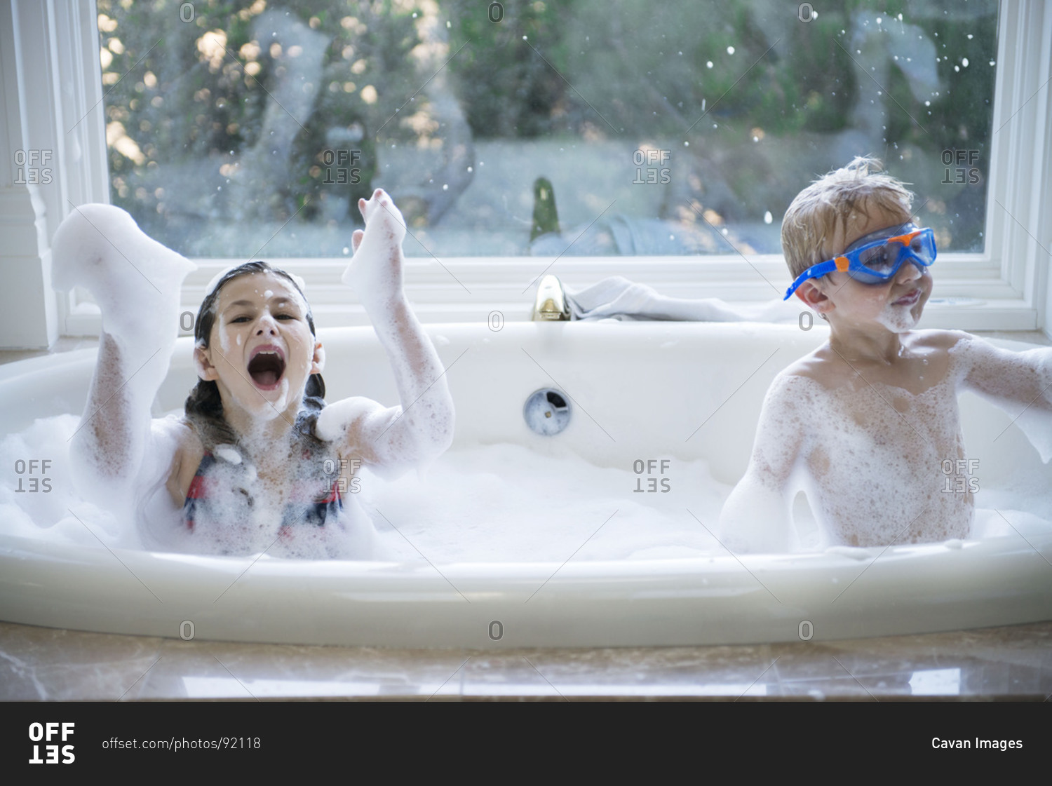 Children play in bubble bath stock photo - OFFSET