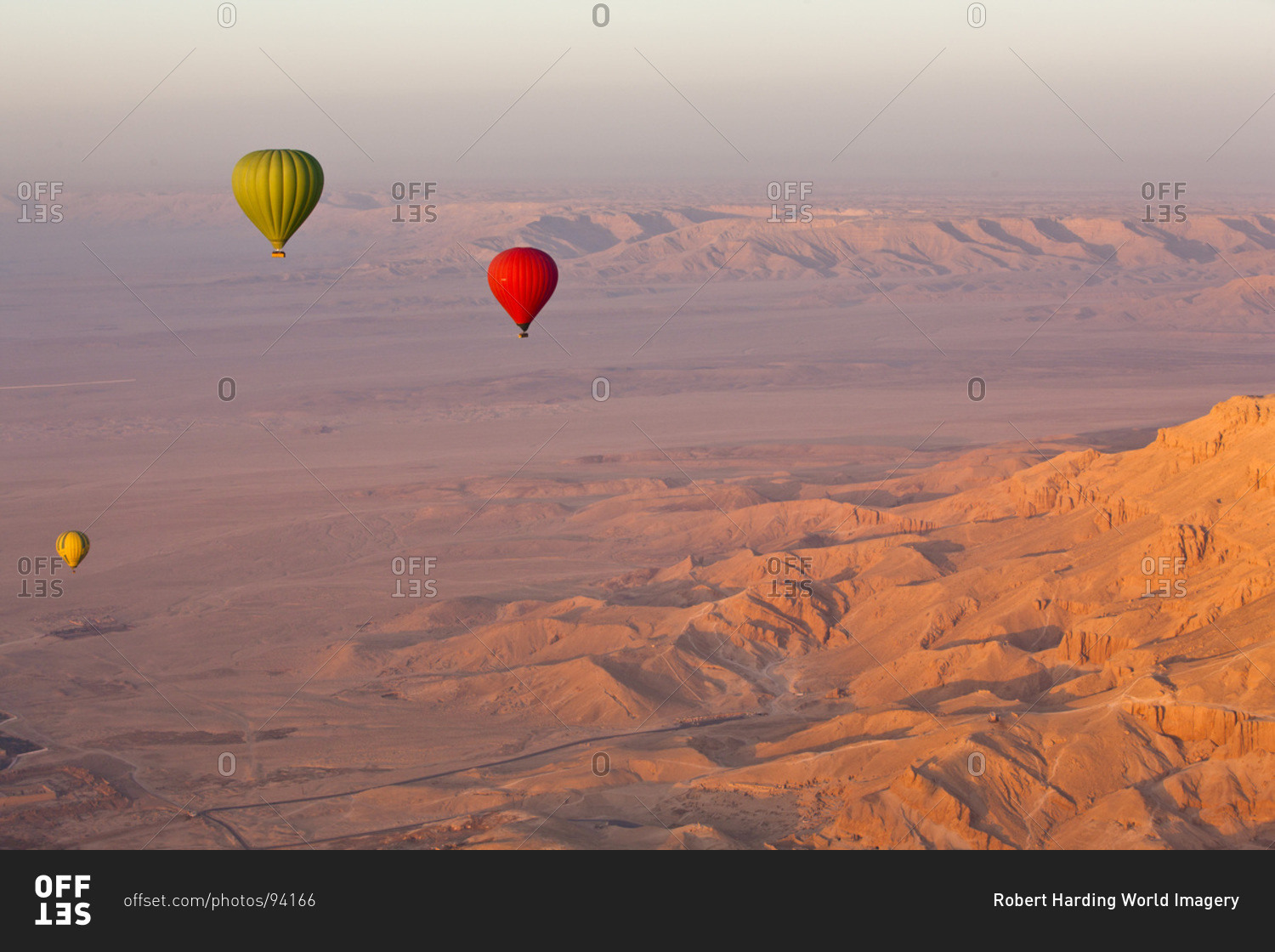 Hot air balloons suspended over the Theban hills of Luxor and the Valley of the Queens at sunrise, Thebes, Egypt, North Africa, Africa