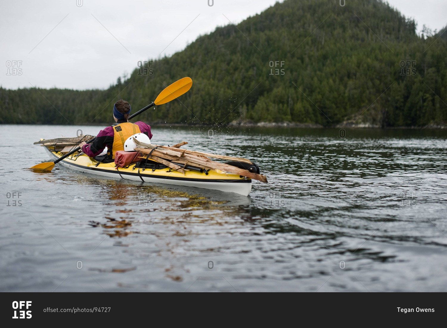 A girl paddles off in a sea kayak