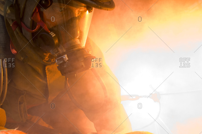 A firefighter practices fast escape drills while surrounded by simulated explosions, smoke and fire.