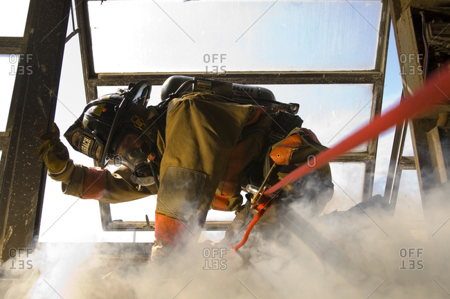 A firefighter practices fast escape drills while surrounded by simulated explosions, smoke and fire.