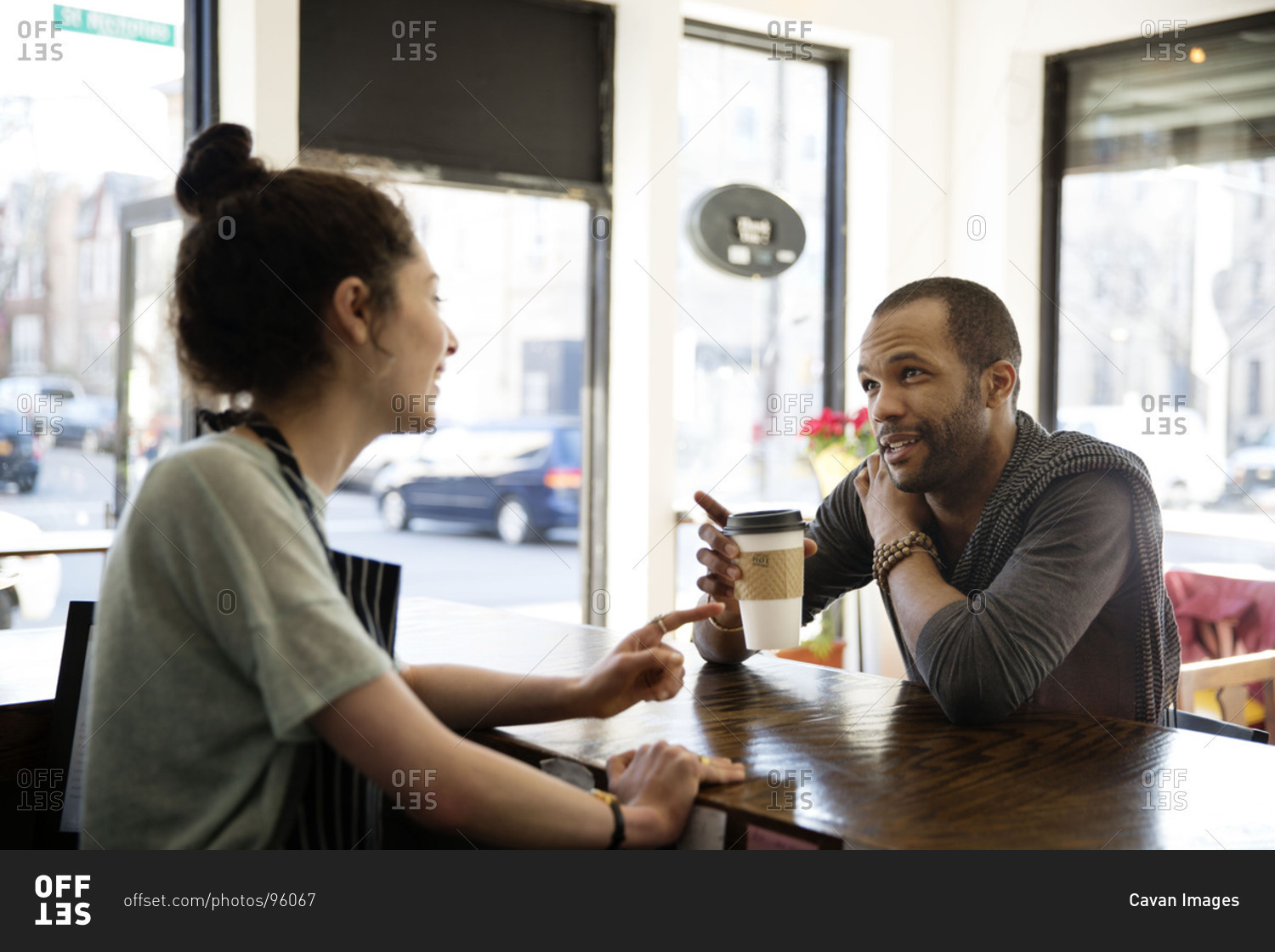Barista talking with a customer at a coffee shop stock photo OFFSET