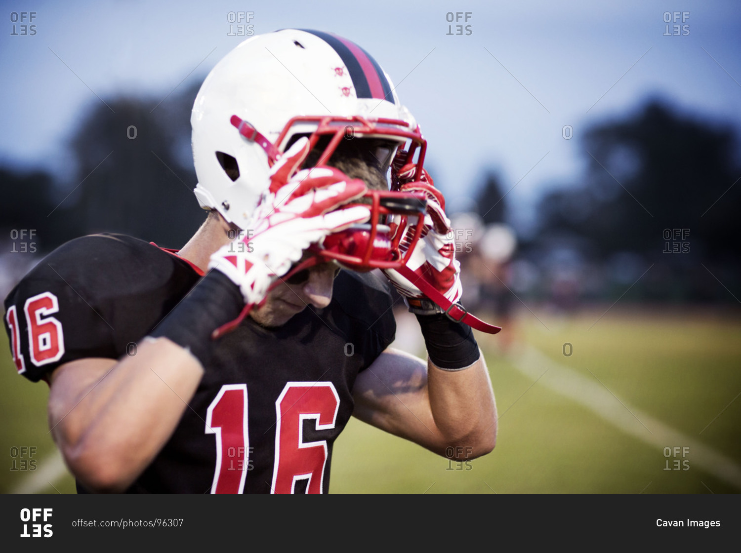 Football player taking off his helmet stock photo OFFSET
