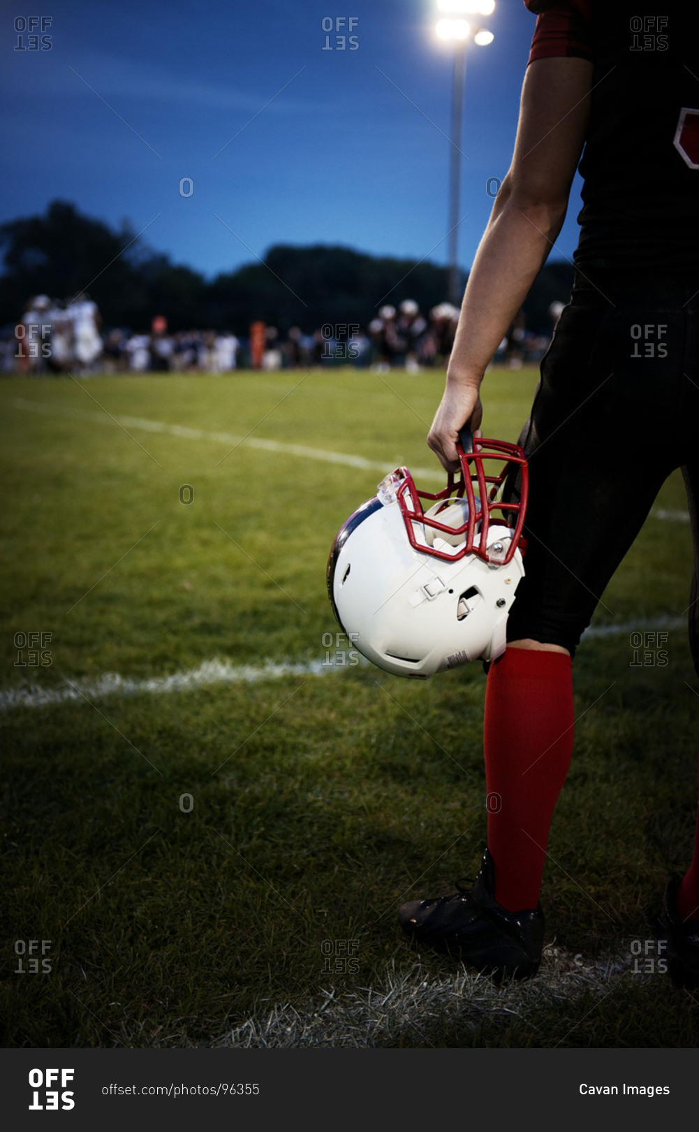 Football player holding his helmet stock photo OFFSET