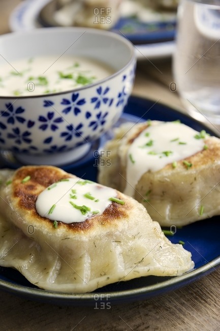 Fried herbed pierogi with a beet, sauerkraut and potato filling, served with soy yogurt and chives