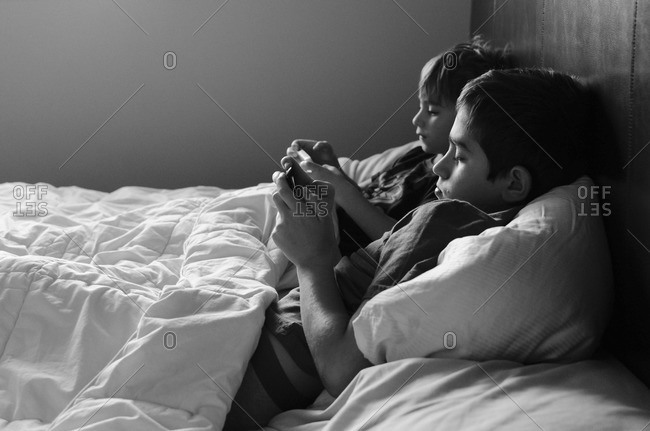 Brothers playing in parent's bed