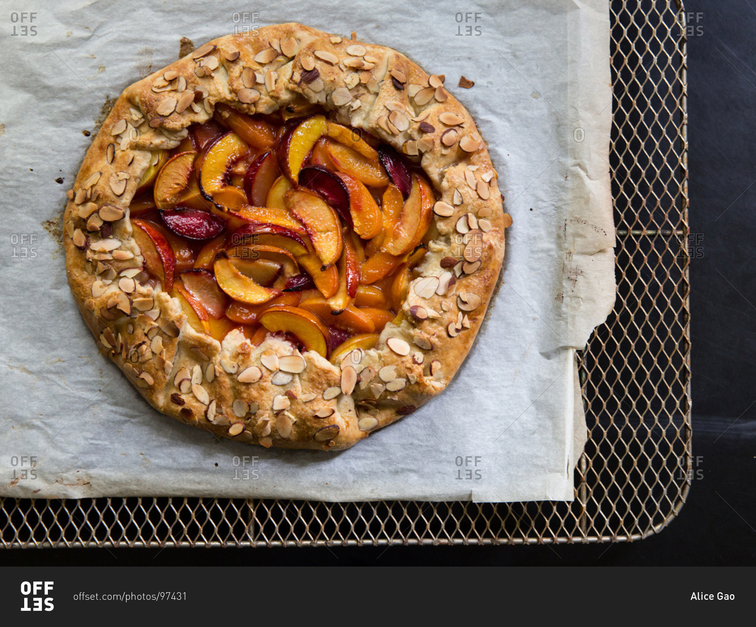 Top view of rustic stone fruit galette with almond flakes